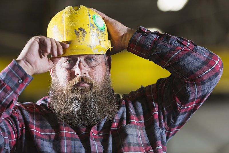 Bearded-construction-worker-putting-on-hardhat