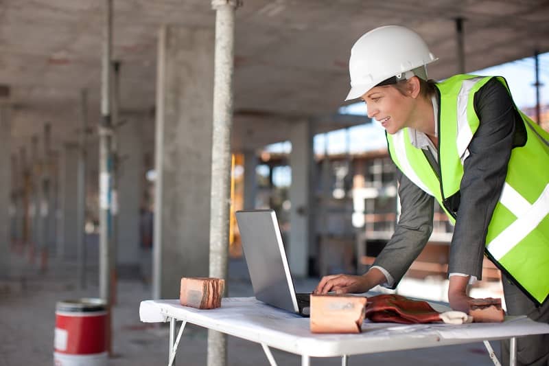 Construction worker using laptop on construction site-cm (1)