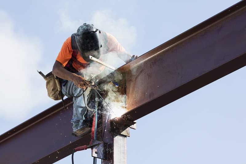 Hispanic ironworker welding a steel girder-cm