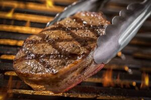 Grilling Filet Mignon Steak on a grill with Fire-cm