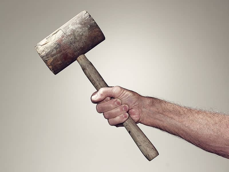Hand holding wooden mallet-cm