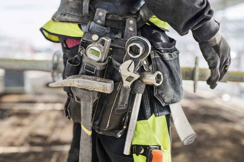 Midsection of construction worker wearing tool belt at site-cm